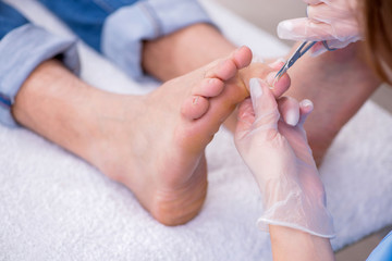 Obraz na płótnie Canvas Podiatrist treating feet during procedure