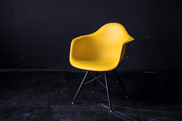 Modern yellow chair in black room interior parquet wood floor