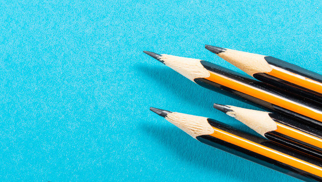 Four pencil tips, macro commercial image on a blue background with copy space for insert text.