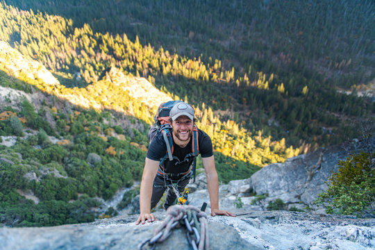 Man smiling while looking up jugging rope on East Ledges El capitan
