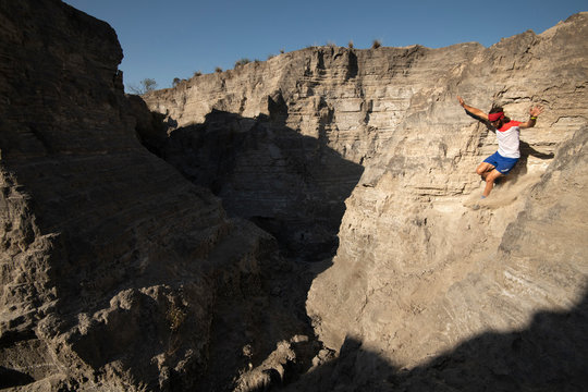 One man descending on a sandy and steep terrain at an old mining area