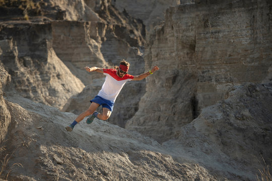 One man running down fast on sandy and arid terrain