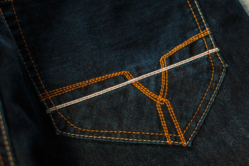 Etykieta skórzana, odzieżowa, zbliżenie spodni jeansowych.