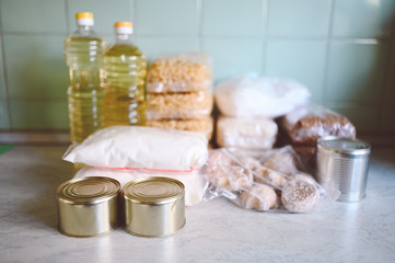 Volunteer donation various product set for poor or elderly people. Pandemic coronavirus food shortages. Food donations or delivery concept on kitchen background. 