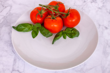 cherry tomatoes on a plate with basil 