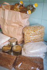 Fototapeta na wymiar Volunteer donation various product set for poor or elderly people. Pandemic coronavirus food shortages. Food donations or delivery concept on kitchen background. 