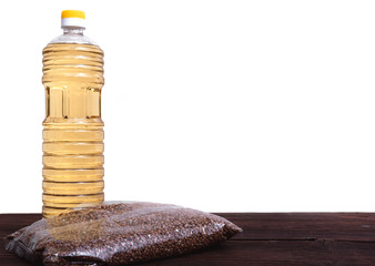 Raw porridge in a package and a bottle of sunflower oil. Stocks of cereals in the package.