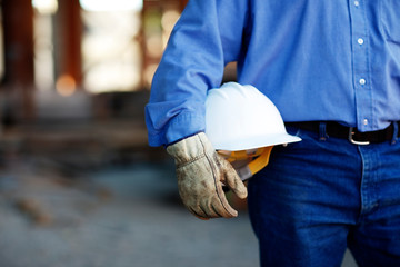 Close up of a male construction foreman worker holding a hard ha
