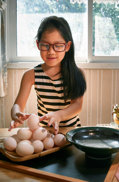 A girl arranges the eggs on a bamboo tray