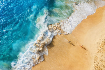 Mensen op het strand op Bali, Indonesië. Vakantie en avontuur. Strand en grote golven. Bovenaanzicht van drone op strand, azuurblauwe zee en ontspannen mensen. Reis en ontspan - afbeelding