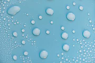 Close-up drops of water on blue surface, raindrops, background or texture 
