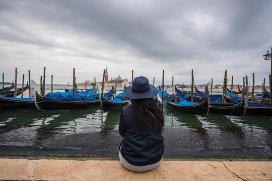 woman looking at gondolas in the Venice Lagoon, Venice, Italy