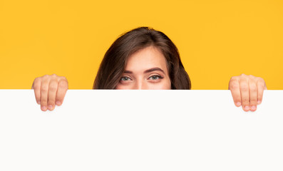 Woman hiding behind empty banner