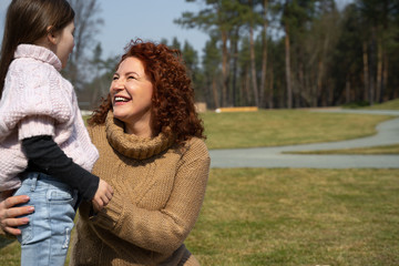 Loving mother spending time with cute daughter outdoors