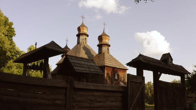 Entrance to and old wooden orthodox church. Sky with small clouds.
