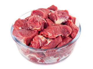 Pieces of fresh beef in a glass bowl isolated on white background