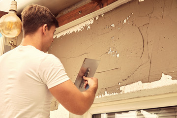 Construction worker plaster a wall.