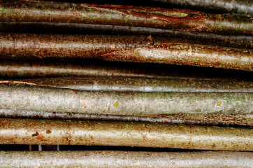 Background of wooden rods, dark brown pattern, close up.