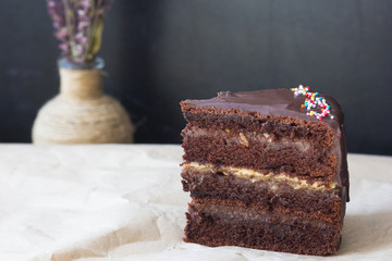 Piece of layered chocolate cake on the craft paper
