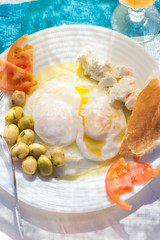 Poached fried eggs with goat's cheese, tomatoes and olives, Moroccan breakfast 