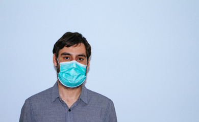 portrait of man with beard and casual clothes and surgical mask on white background. social distancing