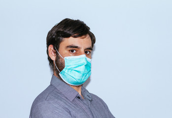 portrait of man with beard and casual clothes and surgical mask on white background. social distancing