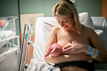 Breastfeed Mother with her newborn baby at the hospital a day after a natural birth labor