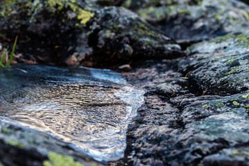 A picturesque close-up view of a frozen puddle on a rock in the Pyrenees mountains on a winter day (Arrens-Marsous, Hautes-Pyrenees, France)
