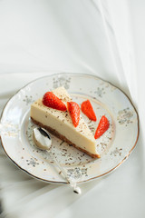 Piece of cheesecake with fresh strawberries  on white background