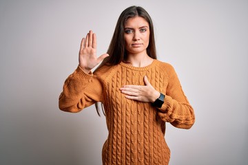 Young beautiful woman with blue eyes wearing casual sweater standing over white background Swearing...
