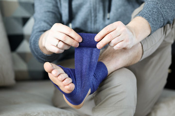 Man pulls his leg after stretching with bandage