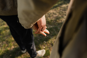 happy young pregnant couple walks in the park,husband holds the hand of his pregnant wife,future dad and mom,walks in the park after quarantine