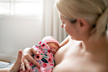 Obraz na płótnie Canvas woman in her bedroom breastfeed her baby.
