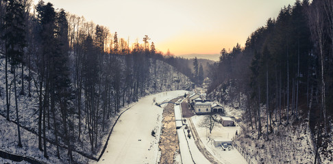 View from the dam in Miedzygorze, flowing river in a mountain valley in winter.