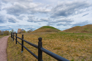 Fototapeta na wymiar The Royal Mounds (Kungshogarna) three large barrows located in Gamla Uppsala. Archeological site in Sweden near Stockholm.