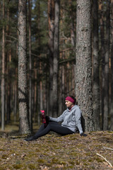 Fototapeta premium Girl in the woods drinks water after jogging