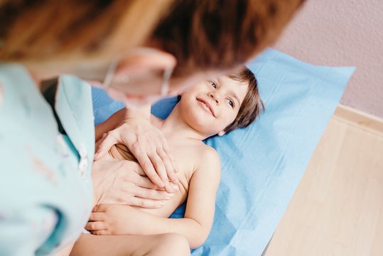 Nurse examining little boy in clinic