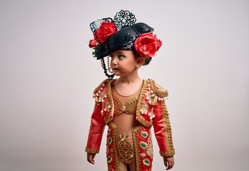 Young little caucasian kid girl wearing  bullfighter traditional folkore spanish suit as carnival...
