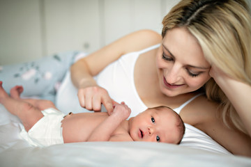 Obraz na płótnie Canvas A woman with a newborn baby in bed