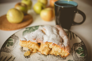 Apple pie on a plate with a green pattern. A cup of tea. A cup of coffee. Apples on the table. Green apples. A feast of apples. Tea party Tasty food. White background.