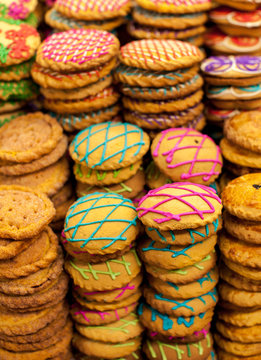 From above closeup of stacked sweet cookies decorated with colorful icing on table