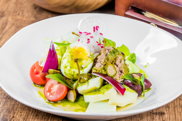A plate of nicoise salad on a table