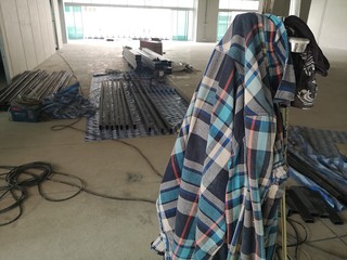 Plaid shirt of the mechanic worker laying on the construction site