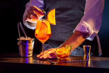 Bartender decorating Aperol spritz cocktail