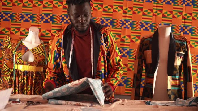 Busy black tailor working at workshop