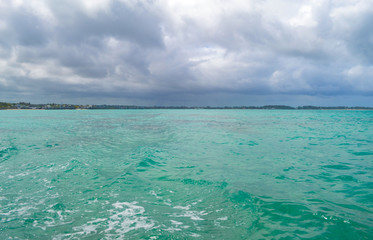 Turquoise sea and distant coast in cloudy cloudy weather