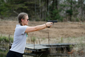 Woman aiming a pistol.