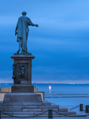 Fototapeta na wymiar silhouette of monument of city founders in Odessa in Ukraine in the morning twilight with view to sea and copy space