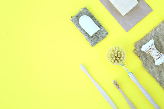 Eco product on the yellow background with wooden goods such toothe brush cotton buds