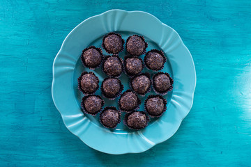 Brigadeiro. Delicious Traditional Brazilian sweet on blue plate and blue background.